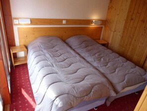 A double bed with a wooden headboard and two bedside tables.