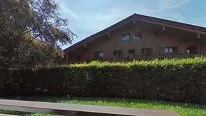A wooden building with a flat roof, surrounded by a well-maintained hedge. - Ground floor, balcony, tv, 31m², Le Grand Bornand (Le Grand-Bornand)