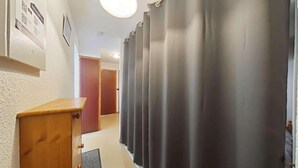 A hallway with a wooden cabinet, a door, and a curtain. - Ground floor, balcony, tv, 31m², Le Grand Bornand (Le Grand-Bornand)