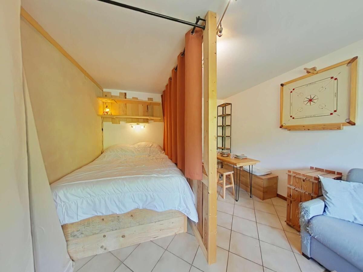 Ein Schlafzimmer mit einem hölzernen Bett, einem Schreibtisch und einem Stuhl.