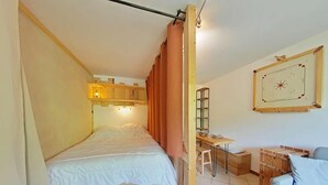 Ein Schlafzimmer mit einem hölzernen Bett, einem Schreibtisch und einem Stuhl.