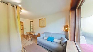 Ein Wohnzimmer mit einer Couch, einem Couchtisch und einem Essbereich.