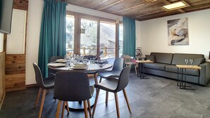 A dining area with a round table, chairs, and a sofa. - 200m from ski slopes, Ground floor, terrace, tv, 42m², Les Menuires (Les Menuires)