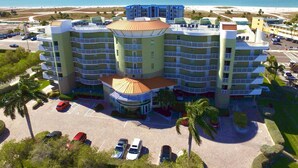 Ein mehrgeschossiges Hotel mit Innenhof, Parkplatz und Blick auf den Strand.