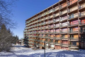 Stunning building with a unique architectural style, featuring multiple balconies with metal railings and windows.