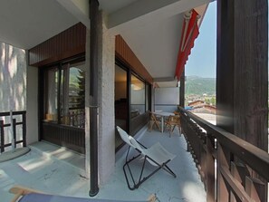 A balcony with a wooden railing, a table, and two chairs. - 2nd floor, view mountain, tv, 58m², Le Grand Bornand (Le Grand-Bornand)
