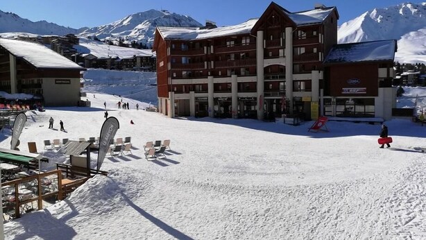 A snow-covered ski resort with a multi-story building, ski lifts, and a mountain backdrop. - 70m from ski slopes, 1st floor, view ski slopes, balcony, ski locker, 25m², La Plagne (La Plagne)