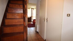 A wooden staircase leading to a room with a red carpet and a white door. - 50m from ski lifts, 1st floor, terrace, parking, tv, 50m², Montgenèvre (Montgenèvre)