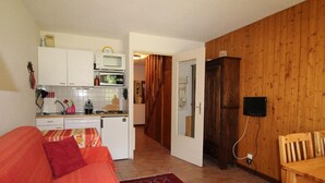 A compact living space with a kitchenette, a dining area, and a cozy seating area. - 50m from ski lifts, 1st floor, terrace, parking, tv, 50m², Montgenèvre (Montgenèvre)