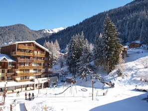 A ski resort with wooden buildings, a ski lift, and snow-covered trees. - 10m from resort center, 1st floor, parking, tv, ski locker, 32m², Valfréjus (Valfréjus)