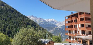 A mountain view with a wooden building featuring balconies and a clear sky. - 20m from ski slopes, 1st floor, parking, tv, ski locker, 32m², Valfréjus (Valfréjus)