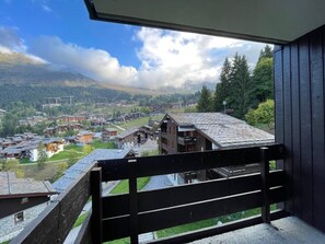 A balcony with a view of a town and mountains.