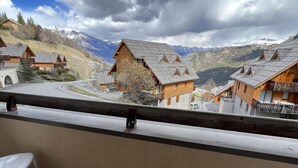 A balcony with a view of a mountain village, wooden houses, and a clear sky. - Ground floor, balcony, ski locker, 35m², Pra Loup (Pra Loup)