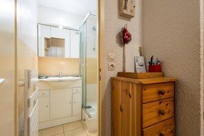 A bathroom with a glass shower enclosure, a sink, and a wooden cabinet. - 1st floor, balcony, ski locker, 33m², Valloire (Valloire)