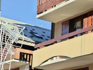 A multi-story building with balconies, a visible window, and a metal structure on the roof. - 1st floor, balcony, ski locker, 33m², Valloire (Valloire)