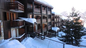 Un edificio de madera con varios balcones y un techo cubierto de nieve.