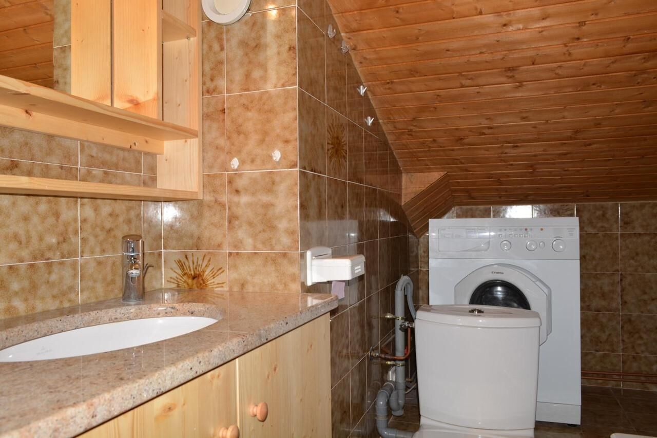 A bathroom with a sink, toilet, and washing machine.