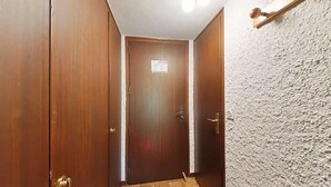 A hallway with wooden doors and a textured wall.