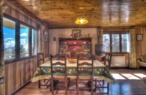 Enjoy meals with family and friends at the large dining table, surrounded by a warm fireplace and stunning views.