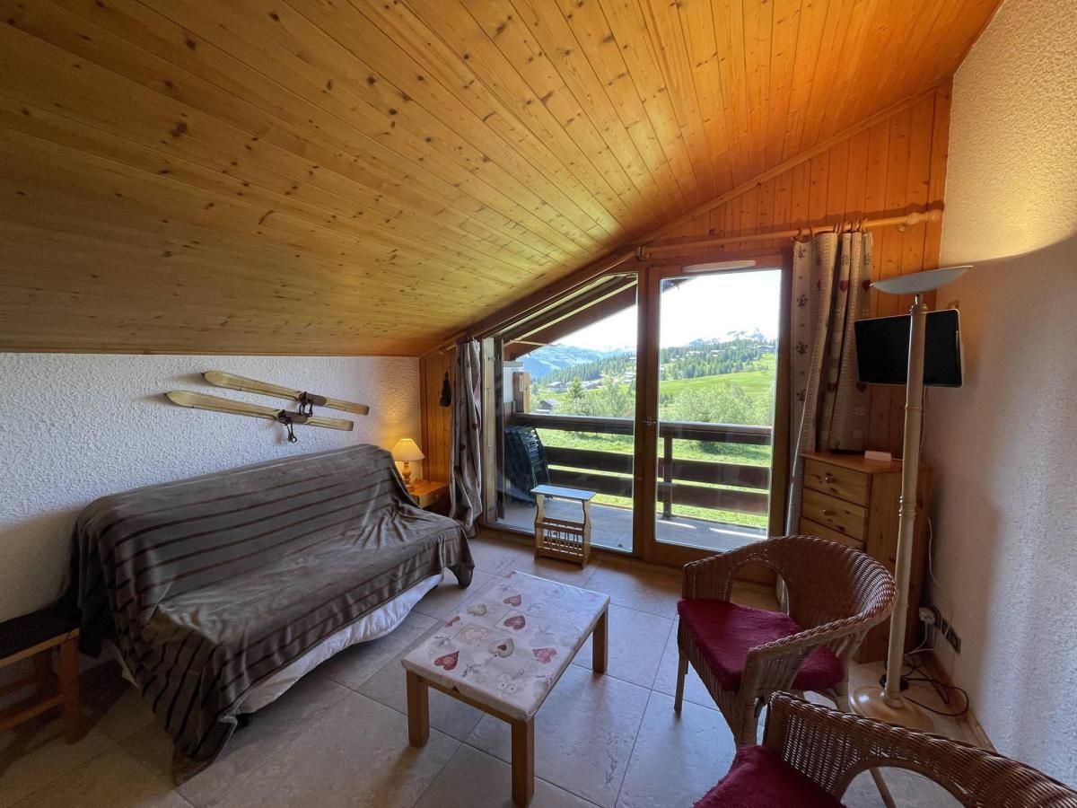 Una habitación acogedora con una cama, una mesa, una silla y vistas al exterior.