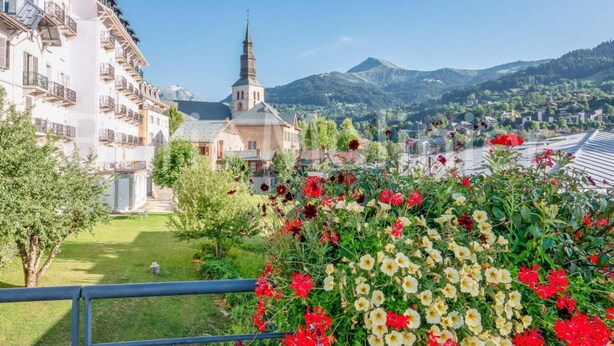 Un hôtel avec vue sur une église et des montagnes.