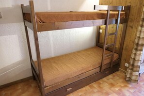 Een stapelbed met een houten frame en een matras.
