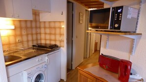 A compact kitchen with a washing machine, a microwave, and a toaster. - 200m from ski slopes, 3rd floor, view mountain, balcony, parking, tv, ski locker, 38m² (Les Contamines-Montjoie)