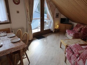 Cozy living area with dining space, sofa, and TV.