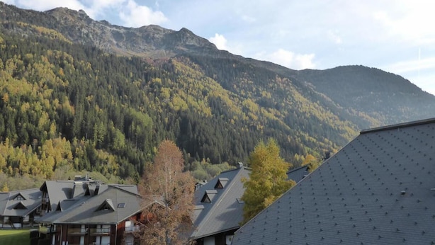 A mountain lodge with multiple buildings, a forested backdrop, and a clear sky. - 200m from ski slopes, 3rd floor, view mountain, balcony, parking, tv, ski locker, 38m² (Les Contamines-Montjoie)