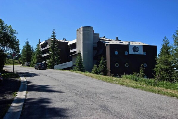 Un bâtiment moderne doté d’une conception architecturale unique, caractérisé par une grande structure cylindrique et une façade ornée de motifs circulaires.
