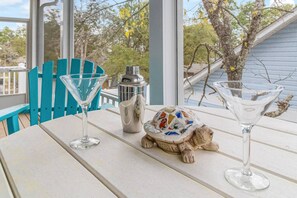 Uma mesa com dois copos de martini, uma pequena estatueta e uma garrafa.