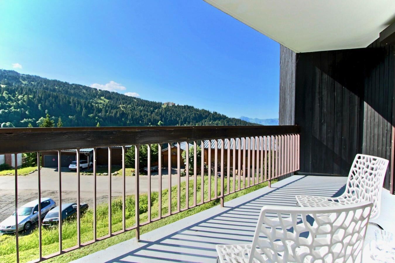 Ein Balkon mit Blick auf einen Parkplatz und Berge.