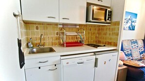 A compact kitchen with a microwave, sink, and dishwasher. - 100m from ski slopes, 3rd floor, tv, ski locker, 21m², Chamrousse (Chamrousse)