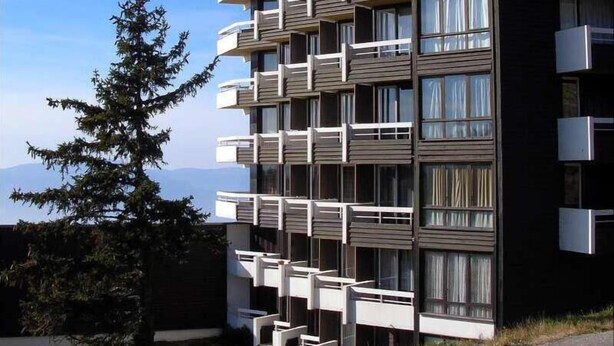 A modern multi-story building with balconies, large windows, and a clear view of the surrounding landscape. - 300m from ski slopes, 6th floor, balcony, tv, 27m², Chamrousse (Chamrousse)