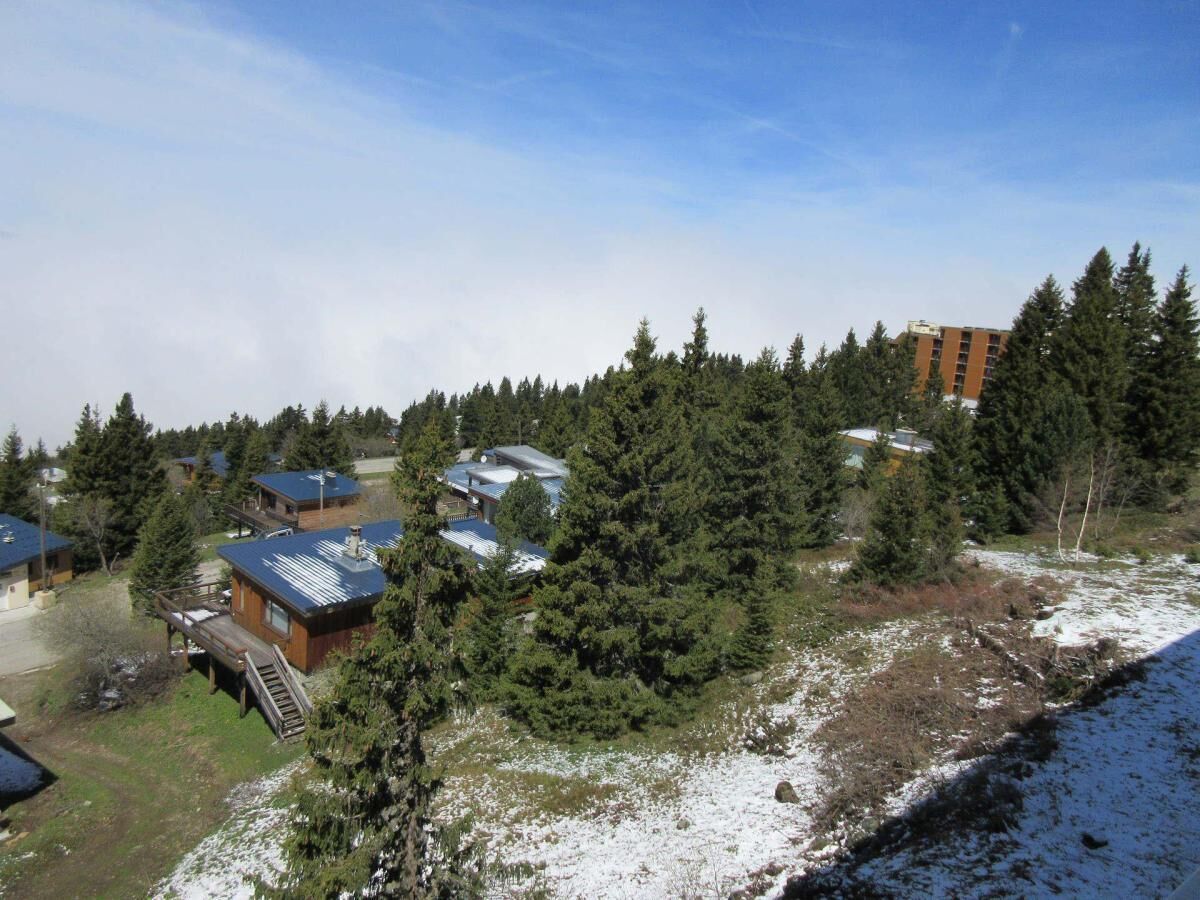 A residential area with multiple houses surrounded by dense forest.