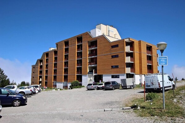 A multi-story hotel with a modern design, featuring a mix of wooden and concrete facades.