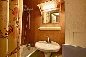 A bathroom with a shower curtain, a sink, a mirror, and a towel rack. - 100m from ski slopes, 1st floor, balcony, ski locker, 19m², Chamrousse (Chamrousse)