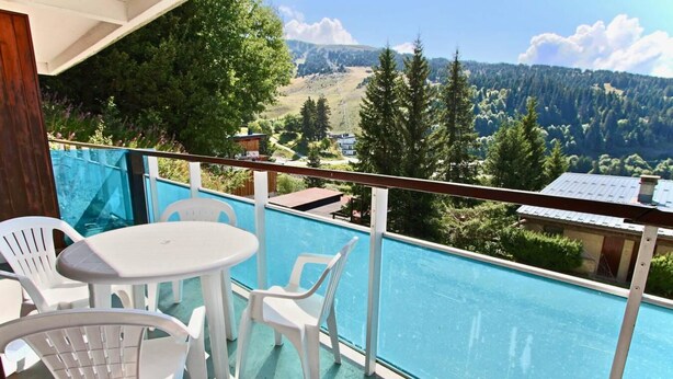 A balcony with a pool, white plastic chairs, and a table. - 300m from ski slopes, 1st floor, balcony, tv, 35m², Chamrousse (Chamrousse)