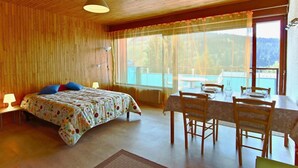 A room with a bed, a dining table with chairs, a window with curtains, and a ceiling with wooden panels. - 300m from ski slopes, 1st floor, balcony, tv, 35m², Chamrousse (Chamrousse)