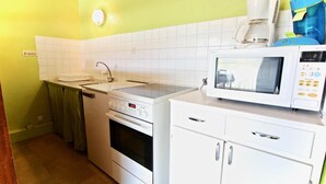 A compact kitchen with a stove, oven, microwave, and a coffee maker. - 300m from ski slopes, 1st floor, balcony, tv, 35m², Chamrousse (Chamrousse)