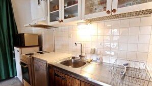 A compact kitchen with a stainless steel sink, wooden cabinets, and a dish rack. - 300m from resort center, 2nd floor, balcony, tv, 55m², Chamrousse (Chamrousse)