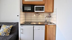 Une petite cuisine équipée d’un four à micro-ondes, d’un grille-pain et d’un lave-vaisselle.
