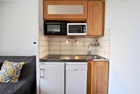 Efficient kitchenette with microwave, toaster, and dishwasher for basic food preparation needs.