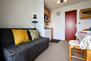 Cozy living space with a sofa, dining area, and kitchenette, perfect for a compact stay.