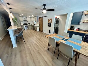 Eine moderne Küche mit Essbereich, Holzboden und Deckenventilator.