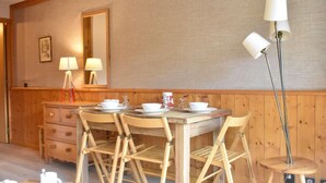 Una mesa de comedor de madera con sillas, un espejo y una lámpara.