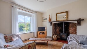 Una sala de estar acogedora con chimenea, televisor y asientos cómodos.