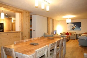 Enjoy meals and social gatherings in this inviting living space with a dining table and chairs.