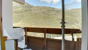 A balcony with a view of a mountainous landscape.