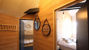 A wooden interior with a bunk bed, a mirror, and a bed with pillows. - 3rd floor, tv, ski locker, 100m², Serre Chevalier (Briançon)